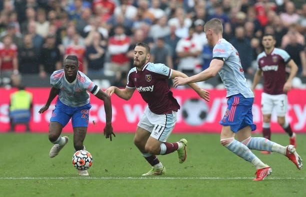 West Ham United's Nikola Vlasic gets in between Manchester United's Scott McTominay and Aaron Wan-Bissaka during the Premier League match between...
