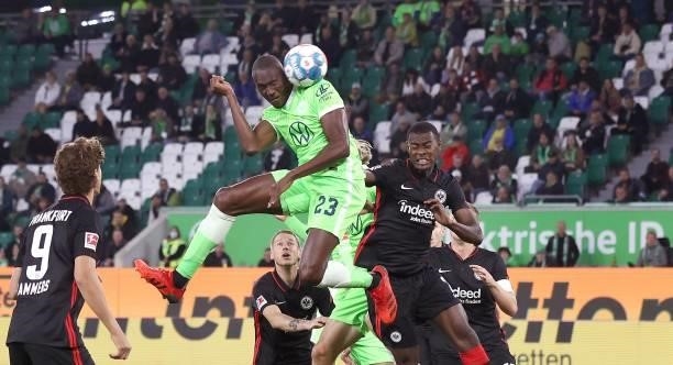Wolfsburg's French midfielder Josuha Guilavogui and Frankfurt's French defender Evan N'Dicka head for the ball during the German first division...