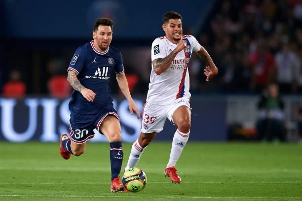 Leo Messi of PSG and Bruno Guimaraes of Olympique Lyonnais compete for the ball during the Ligue 1 Uber Eats match between Paris Saint Germain and...