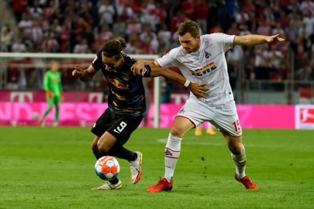 Yussuf Poulsen of RB Leipzig and Luca Kilian of 1. FC Koeln battle for the ball during the Bundesliga match between 1. FC Koeln and RB Leipzig at...
