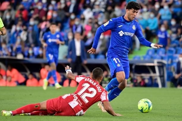 Getafe's Spanish midfielder Carles Alena outpasses Atletico Madrid's Brazilian defender Renan Lodi during the Spanish League football match between...