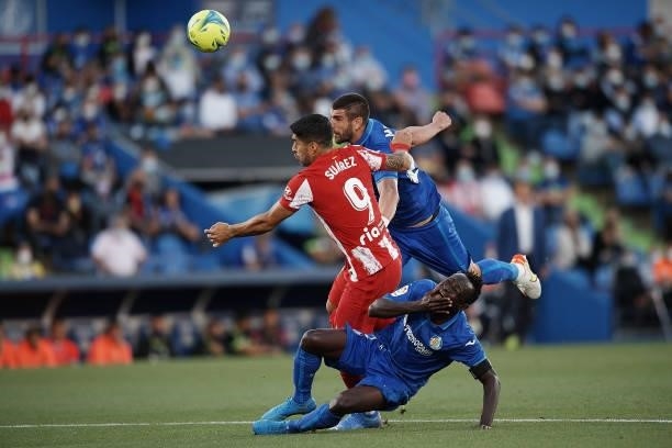 Luis Suarez of Atletico Madrid and Djene, Stefan Mitrovic of Getafe compete for the ball during the La Liga Santander match between Getafe CF and...