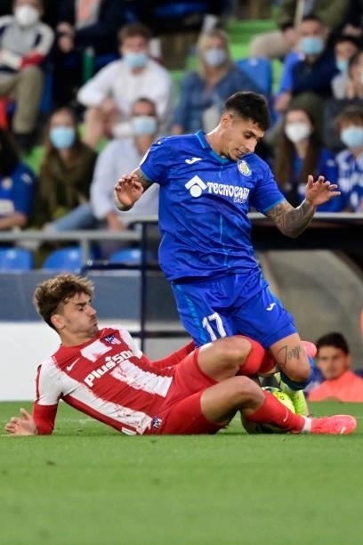 Atletico Madrid's Spanish midfielder Antoine Griezmann vies for the ball with Getafe's Spanish midfielder Carles Alena during the Spanish League...