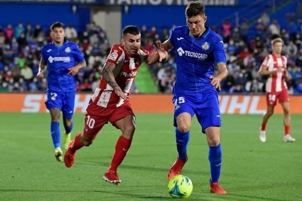 Atletico Madrid's Argentine forward Angel Correa vies with Getafe's Spanish defender Jorge Cuenca during the Spanish League football match between...