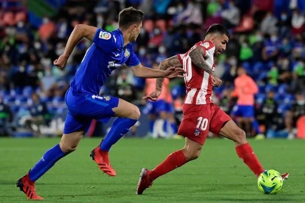 Atletico Madrid's Argentine forward Angel Correa vies with Getafe's Spanish defender Jorge Cuenca during the Spanish League football match between...