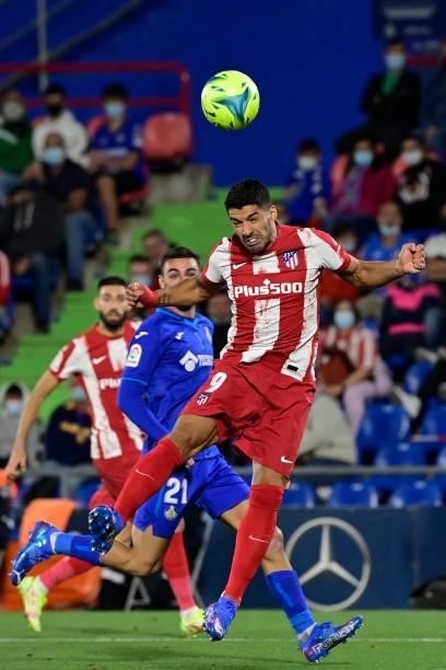 Atletico Madrid's Uruguayan forward Luis Suarez heads the ball during the Spanish League football match between Getafe CF and Club Atletico de Madrid...