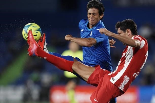 Stefan Savic of Atletico Madrid and Jose Macias of Getafe compete for the ball during the La Liga Santander match between Getafe CF and Club Atletico...