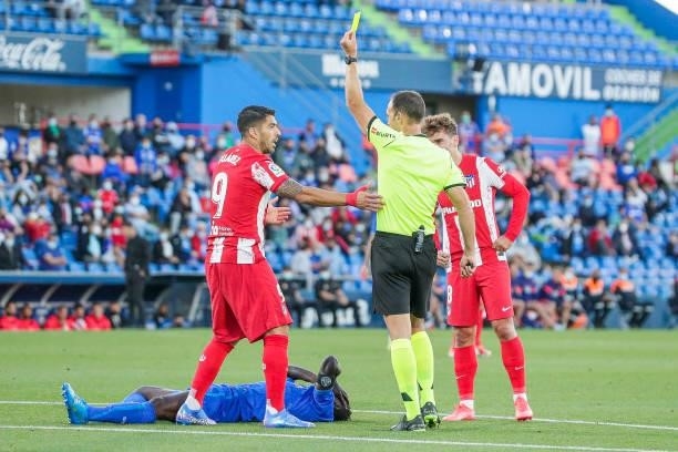 Referee Guillermo Cuadra Fernandez show the yellow card to Luis Suarez of Atletico Madrid during the La Liga Santander match between Getafe v...