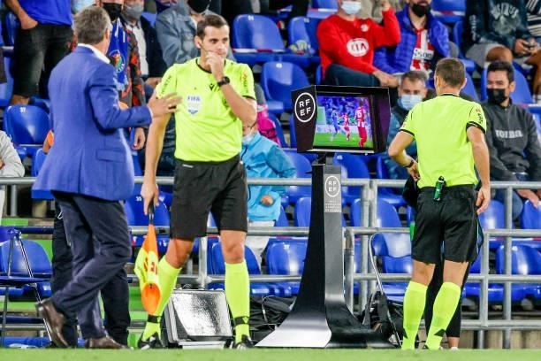 Referee Guillermo Cuadra Fernandez is looking at the VAR screen during the La Liga Santander match between Getafe v Atletico Madrid at the Coliseum...