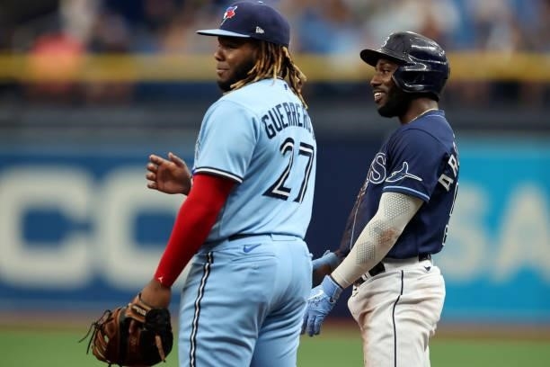 Randy Arozarena of the Tampa Bay Rays speaks with Vladimir Guerrero Jr. #27 of the Toronto Blue Jays after hitting a single in the first inning...