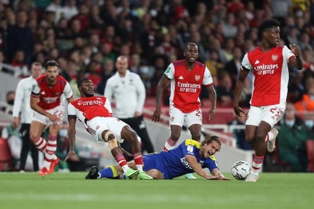 Ainsley Maitland-Niles of Arsenal goes down after passing the ball away from Aaron Pressley of AFC Wimbledon during the Carabao Cup Third Round match...