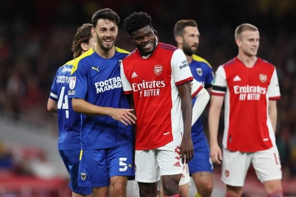 Will Nightingale of AFC Wimbledon and Thomas Partey of Arsenal smile during the Carabao Cup Third Round match between Arsenal and AFC Wimbledon at...