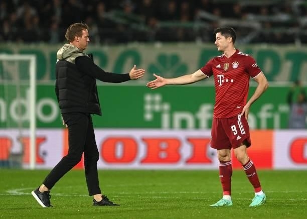 Bayern Munich's headcoach Julian Nagelsmann and Bayern Munich's Polish striker Robert Lewandowski shake hands after the German first division...