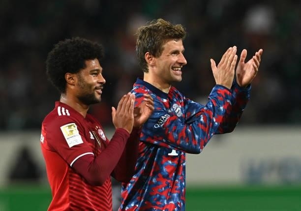 Bayern Munich's midfielder Serge Gnabry and Bayern Munich's striker Thomas Mueller applaud after the German first division Bundesliga football match...