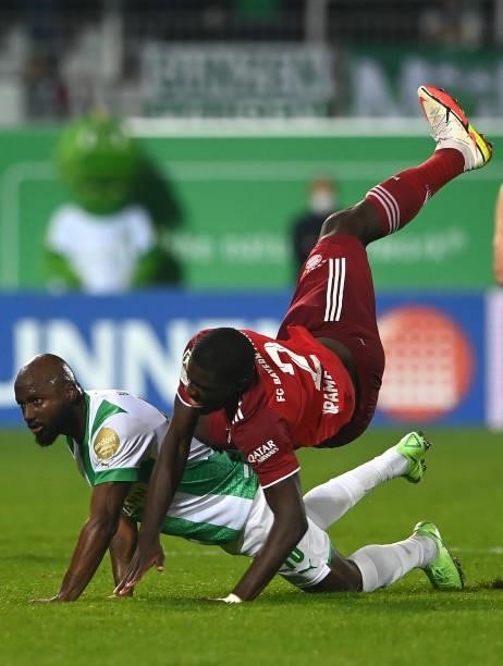 Bayern Munich's French defender Dayot Upamecano falls about Fuerth's Dutch defender Jetro Willems vie for the ball during the German first division...