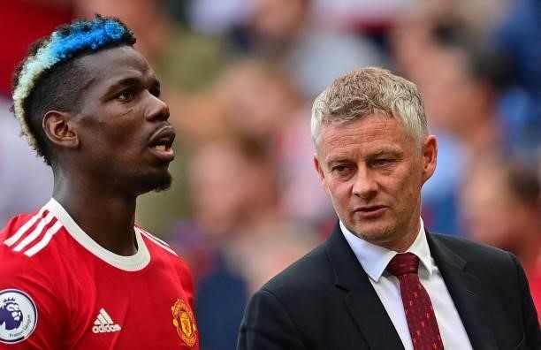 Manchester United's Norwegian manager Ole Gunnar Solskjaer talks with Manchester United's French midfielder Paul Pogba as they leave the pitch at...