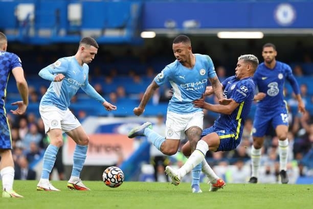 Gabriel Jesus of Man City back heels the ball to Phil Foden as Thiago Silva of Chelsea collides into him during the Premier League match between...
