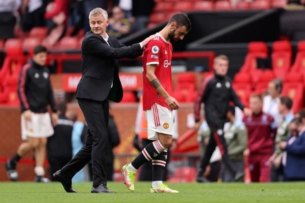 Dejected Bruno Fernandes and Ole Gunnar Solskjaer the manager / head coach of Manchester United walk off dejected after losing to Aston Villa during...