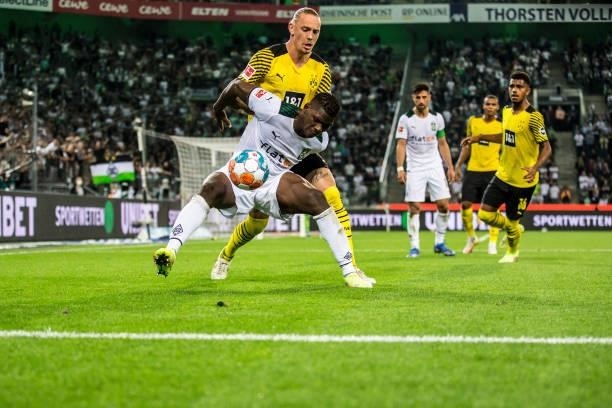 Breel Embolo of Borussia Moenchengladbach and Marius Wolf of Borussia Dortmund in a battle for the ball during the Bundesliga match between Borussia...