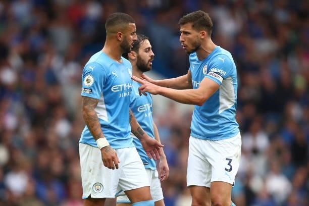 Ruben Dias of Manchester City speaks with team mates Kyle Walker and Bernardo Silva during the Premier League match between Chelsea and Manchester...