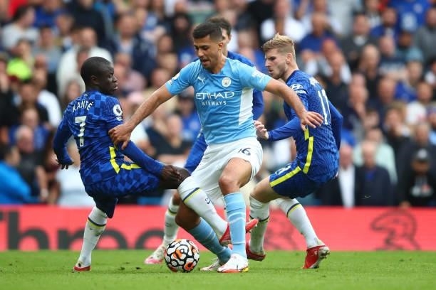 Rodrigo of Manchester City tangles with N'Golo Kante and Timo Werner of Chelsea during the Premier League match between Chelsea and Manchester City...
