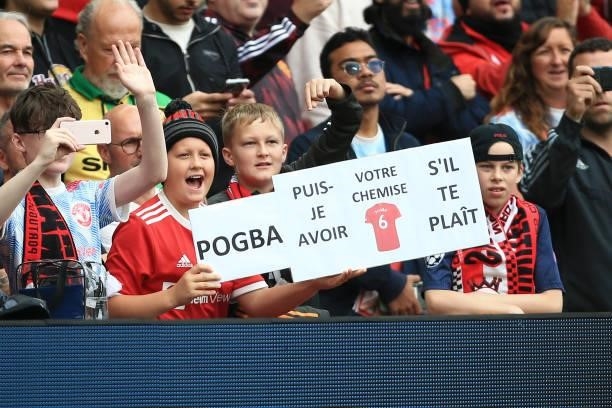 Young Manchester United fans hold up a sign asking Paul Pogba of Manchester United for his shirt during the Premier League match between Manchester...