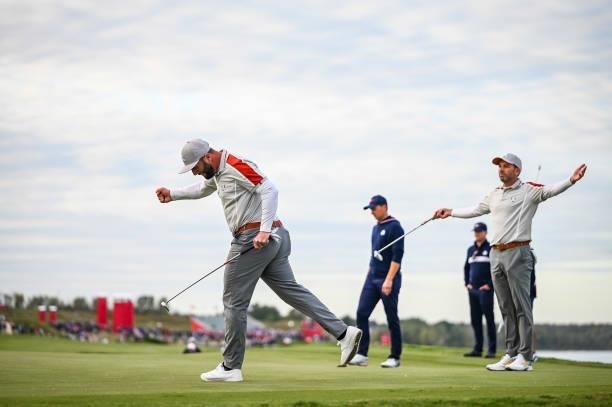 Jon Rahm of Spain and Team Europe pumps his fist after making an eagle putt on the 16th hole green as teammate Sergio Garcia celebrates with arms...