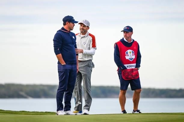 Sergio Garcia of Spain and Team Europe smiles as he speaks to Brooks Koepka of the U.S. Team about a ruling on the 16th hole green during Saturday...