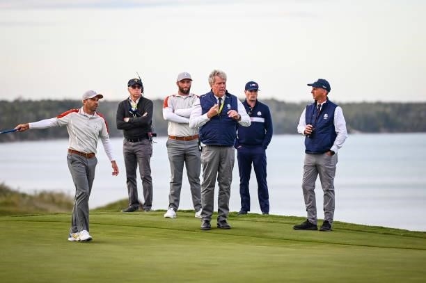 Sergio Garcia and Jon Rahm of Spain and Team Europe speak to a Rules Official on the 16th hole green during Saturday Afternoon Four-ball Matches of...