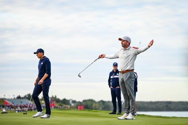 Sergio Garcia of Spain and Team Europe celebrates with arms open after teammate Jon Rahm made an eagle putt on the 16th hole green as Jordan Spieth...