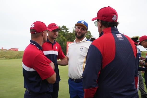 Jon Rahm of Spain and Team Europe visits with United States members Bryson DeChambeau, Scottie Scheffler and United States Vice-Captain Phil...