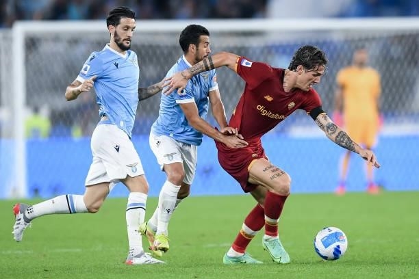 Nicolo' Zaniolo of AS Roma is challenged by Pedro of SS Lazio and Luis Alberto of SS Lazio during the Serie A match between SS Lazio and AS Roma at...