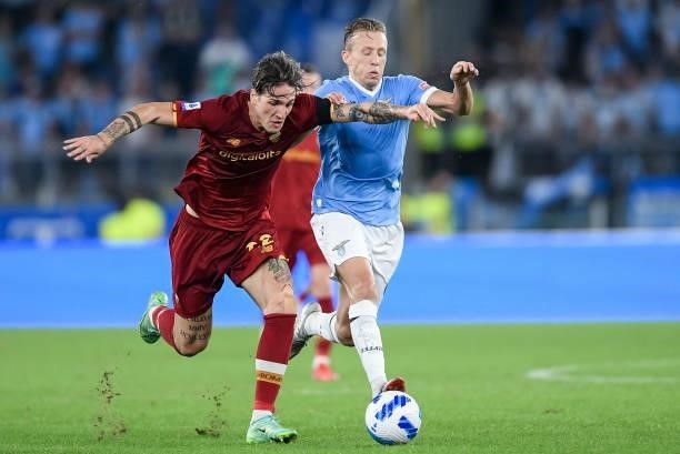 Nicolo' Zaniolo of AS Roma and Lucas Leiva of SS Lazio compete for the ball during the Serie A match between SS Lazio and AS Roma at Stadio Olimpico,...
