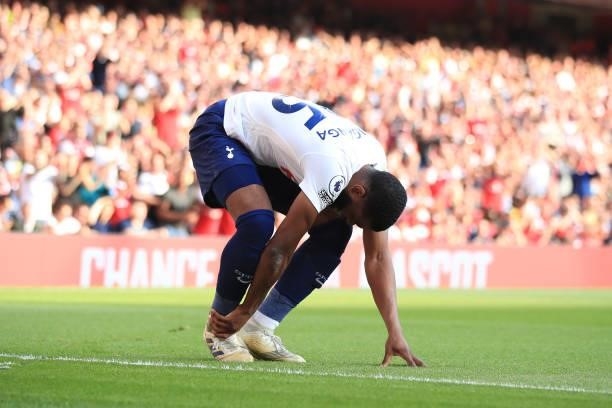 Japhet Tanganga of Tottenham Hotspur holds his ankle after a challenge from Emile Smith Rowe of Arsenal during the Premier League match between...