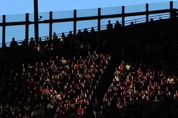 Arsenal fans look on picked out in the late afternoon sunshine during the Premier League match between Arsenal and Tottenham Hotspur at Emirates...