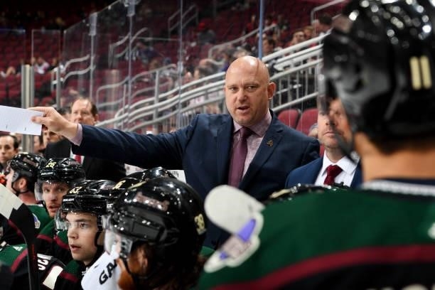Head coach Andre' Tourigny of the Arizona Coyotes talks to Dylan Guenther on the bench during a game against the Los Angeles Kings at Gila River...