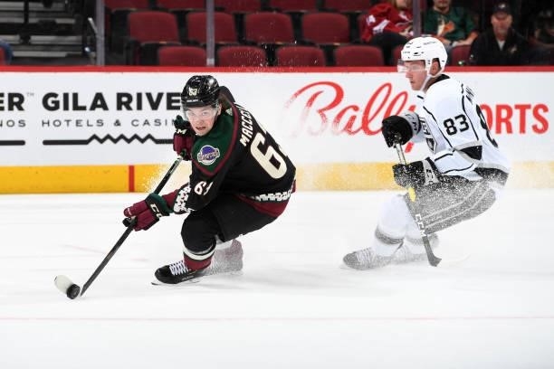 Matias Maccelli of the Arizona Coyotes skates with the puck while being defended by Cade McNelly of the Los Angeles Kings at Gila River Arena on...