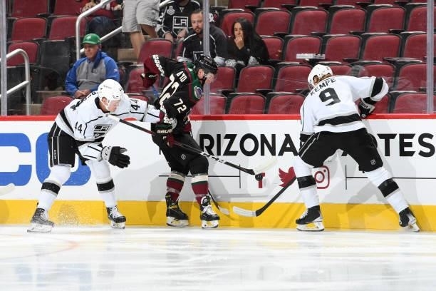 Travis Boyd of the Arizona Coyotes battles for the puck with Adrian Kempe and Mikey Anderson of the Los Angeles Kings at Gila River Arena on...