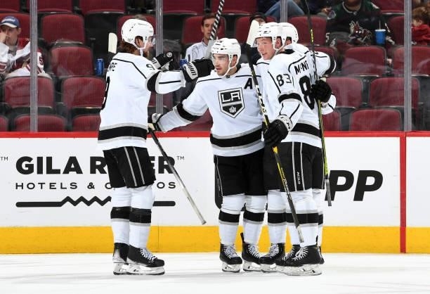 Sean Walker of the Los Angeles Kings celebrates with Adrian Kempe and Cade McNelly after scoring a goal against the Arizona Coyotes at Gila River...