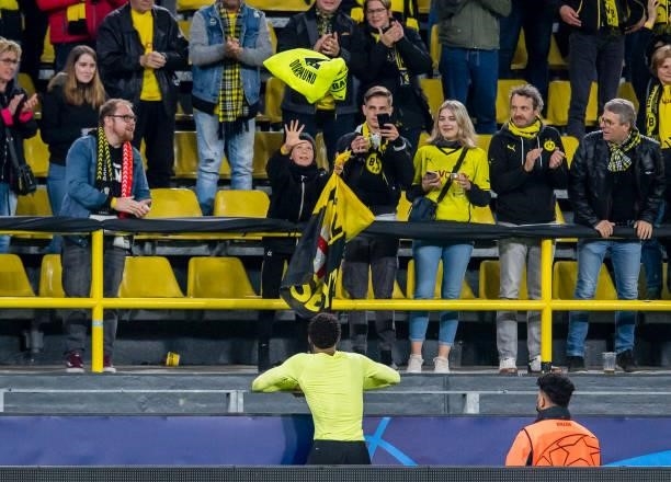 Jude Bellingham of Borussia Dortmund gives away his jersey after the final whistle during the Champions League Group C match between Borussia...