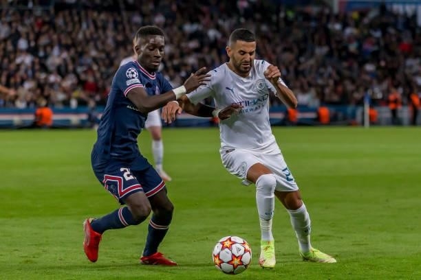 Idrissa Gueye of Paris Saint-Germain and Riyad Mahrez of Manchester City battle for the ball during the UEFA Champions League match between Paris...