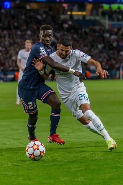 Idrissa Gueye of Paris Saint-Germain and Riyad Mahrez of Manchester City battle for the ball during the UEFA Champions League match between Paris...