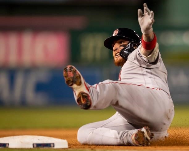Christian Vazquez of the Boston Red Sox slides into third after hitting a go-ahead RBI triple during the ninth inning of a game against the...