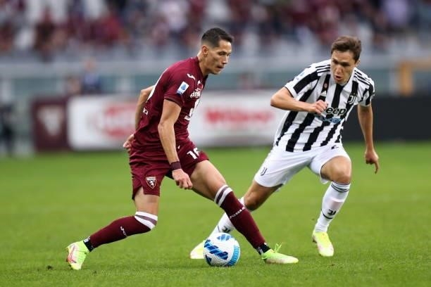 Sasa Lukic of Torino FC and Federico Chiesa of Juventus FC battle for the ball during the Serie A match between Torino FC and Juventus at Stadio...