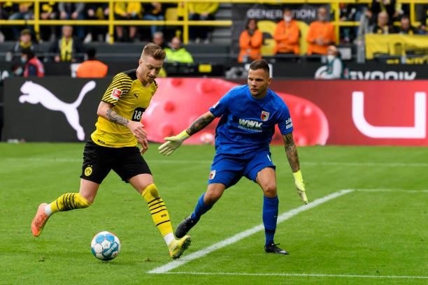 Marco Reus of Borussia Dortmund and goalkeeper Rafal Gikiewicz of FC Augsburg battle for the ball during the Bundesliga match between Borussia...