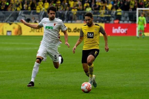 Tobias Strobl of FC Augsburg and Raphael Guerreiro of Borussia Dortmund battle for the ball during the Bundesliga match between Borussia Dortmund and...