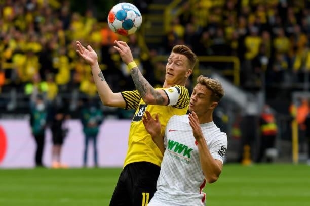 Marco Reus of Borussia Dortmund and Robert Gumny of FC Augsburg battle for the ball during the Bundesliga match between Borussia Dortmund and FC...