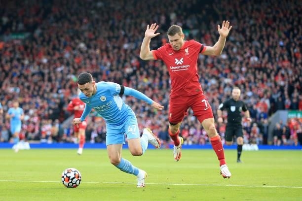 Phil Foden of Manchester City goes down under a challenge from James Milner of Liverpool but no penalty was awarded during the Premier League match...