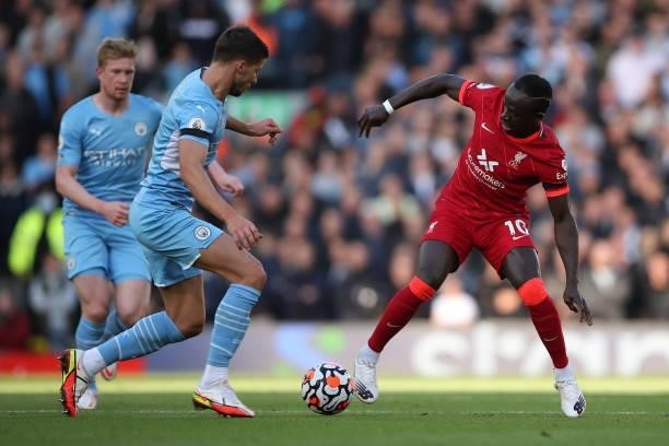 Ruben Dias of Manchester City tackles Sadio Mane of Liverpool during the Premier League match between Liverpool and Manchester City at Anfield on...