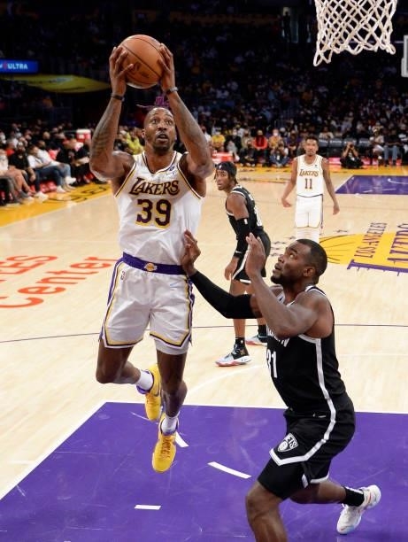 Dwight Howard of the Los Angeles Lakers goes for a layup against Paul Millsap of the Brooklyn Nets at Staples Center during the first half of a pre...